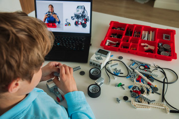 kid building robot with online robotic technology lesson
