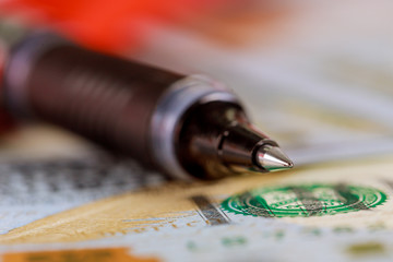 Pen and many hundred US dollar bills on concept of market