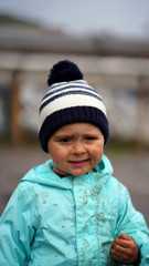 Portrait of a little boy in a hood with earthworm