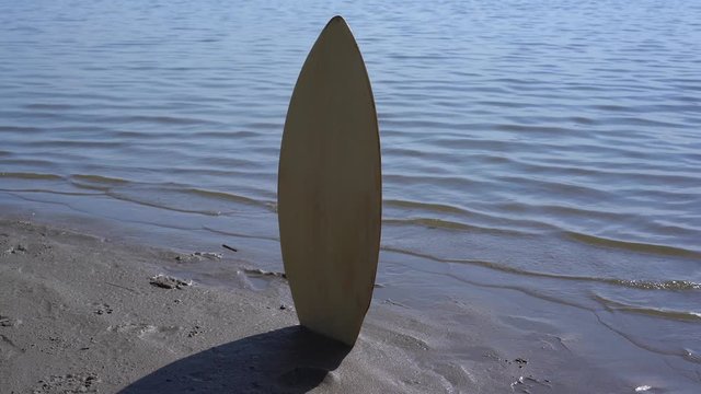 Board for skimboard or short surf stuck in the sand on the beach