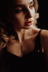 Side dark portrait of sexy glamour woman wearing in elegant black lingerie