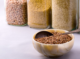 Raw dry buckwheat grain in a bowl with a spoon close-up.