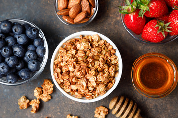 Homemade oatmeal granola bowl with berries on dark background.