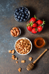 Homemade oatmeal granola bowl with berries on dark background.