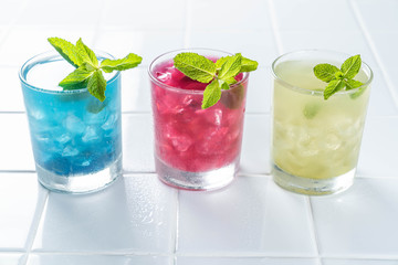 Selection of matcha lemonades - green, blue, red on white background, copy space