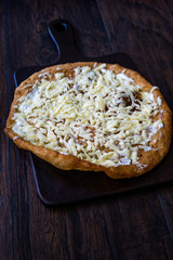Traditional Langos / Langosh are originally Hungarian fried pancakes made from yeast dough, topped with Parmesan cheese and Mild Cream Cheese / Pisi.