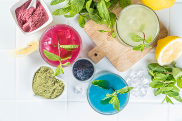 Selection of matcha lemonades - green, blue, red on white background, copy space