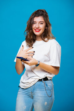Smiling girl with a mobile phone in her hands