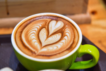 Shapes of art coffee on green cups.