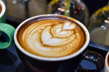 Shapes of art coffee on green cups.