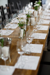 Tables setting at a luxury wedding. Table for guests. Dishes and drinks. Floral decorating, white chairs and table. Wedding table preparation. top view. Vertical photo