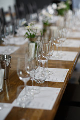 Tables setting at a luxury wedding. Table for guests. Dishes and drinks. Floral decorating, white chairs and table. Wedding table preparation. top view. Vertical photo