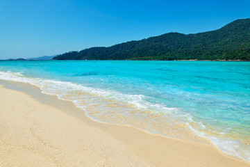 Fototapeta na wymiar Turquoise clear sea and white sand beach on tropical island