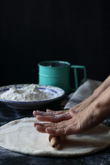 Fototapeta na wymiar Dough ,making dough with flour on a black background, bread and pizza dough