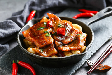 roasted flounder with pepper in pan on black stone board on dark background