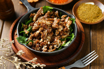 cumin fried lamb in pot on wooden table