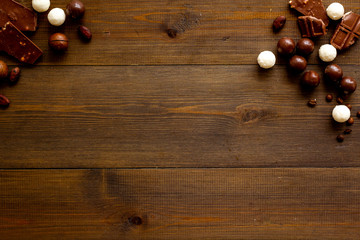 Sweets background with chocolate praline balls on wooden desk top-down frame copy space