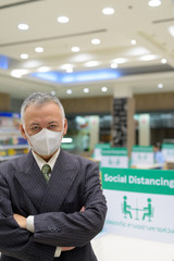 Mature Japanese businessman with mask social distancing at the food court