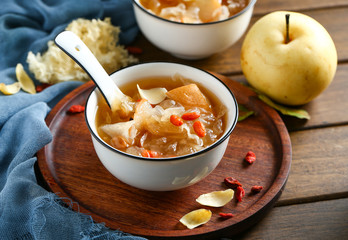 White fungus soup and pear in white bowl on wooden plate
