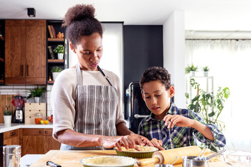 Woman prepare pie in the kitchen and learn his son cooking