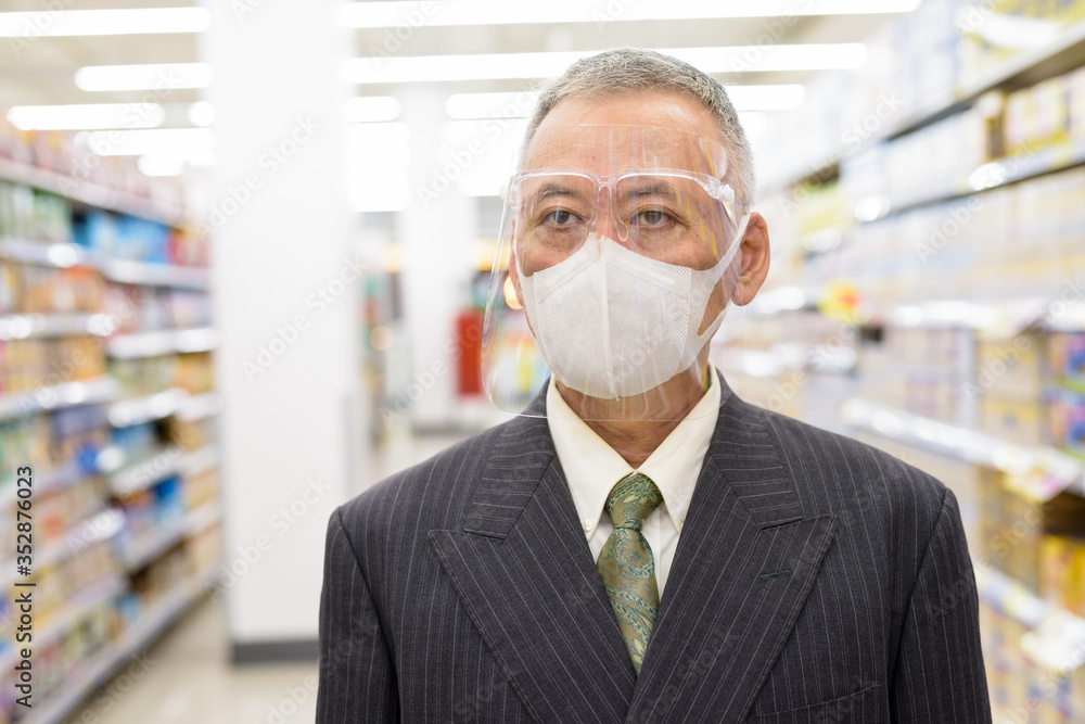 Poster mature japanese businessman with mask and face shield social distancing at the supermarket