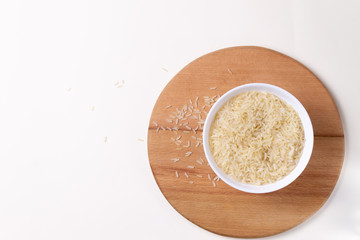 Rice in a white bowl on a round cutting board. Healthy food concept. Copy space. Top view.