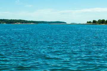 blue sea, far away green trees