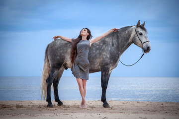Beautyful woman walking on sea with horse