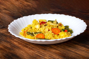 Paella with squid: traditional Spanish dish close-up on a wooden background.