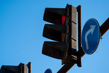 Street traffic light with red light against the blue sky