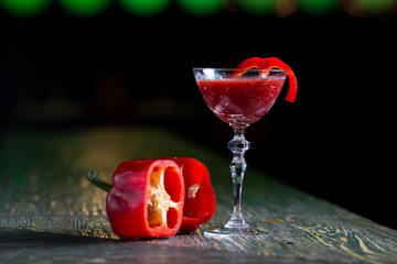 red bloody mary cocktail in a glass on a dark background with pepper