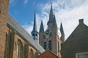 Fototapeta premium Detail of medieval skyline with towers of Old Church in historic city center of Delft, Netherlands. Travel or tourist abstract cityscape. 
