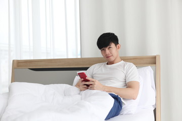 man using mobilephone on bedroom ,  work from home. Technology and communication