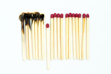 Burnt matches and whole matches on white background. One whole match isolated to stop the fire for...