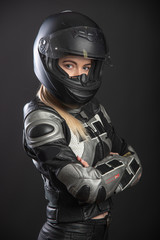 Girl in a motorcycle outfit on a black background