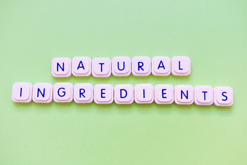 Natural ingredients message made of letter game block over a bright green background.