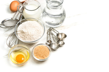 Fototapeta na wymiar Kitchen tools food ingredients eggs flour sugar milk white background