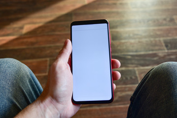 close up man's hand holding mobile phone device with news feed