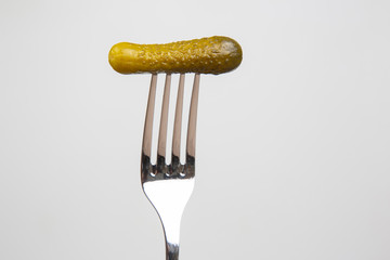 pickled cucumber on a fork. food and vegetables