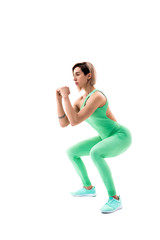 Studio shot of an athletic woman doing squats isolated over white background.