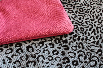 pink cosmetic bag on a leopard-print bedspread