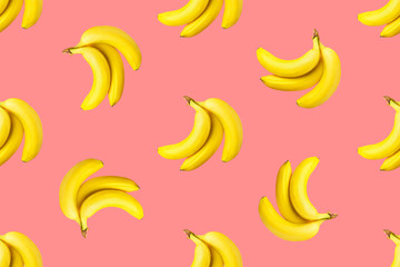 Seamless pattern from bundles of ripe yellow bananas on pink background. Tropical summer fruits concept. Template for wallpaper textile print product surface design