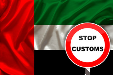 customs sign, stop, attention against the background of the silk national flag of the country of United Arab Emirates, concept border, customs control, violation of state border, tourism restrictions