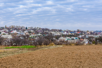 Plowed field at autumn. City Uman on a background. Ukraine