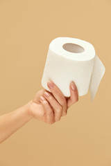 Hygiene. Toilet Paper In Caucasian Female Hand On Beige Background. Using High-Quality Personal Hygiene Product For Staying Healthy.