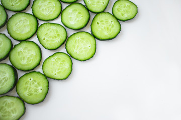 Pattern of cucumber slices on a white background. Left an empty space on the right
