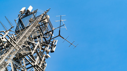 Large communications tower shot against a bright blue sky