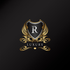 Shield logo in gold color with letter R Logo. Elegant logo vector template made of wide silver alphabet font on shield frame ornate style.
