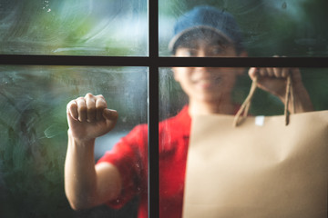 Diverse bags of paper containers for takeaway fast food, Delivery woman in uniform is caring for one of clients, new normal lifestyle for the social distancing and stay at home