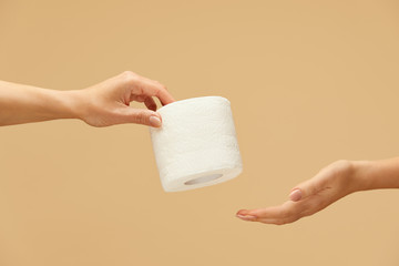Hygiene. Toilet Paper Roll In Caucasian Female Hand On Beige Background. One Woman Gives Tissue...